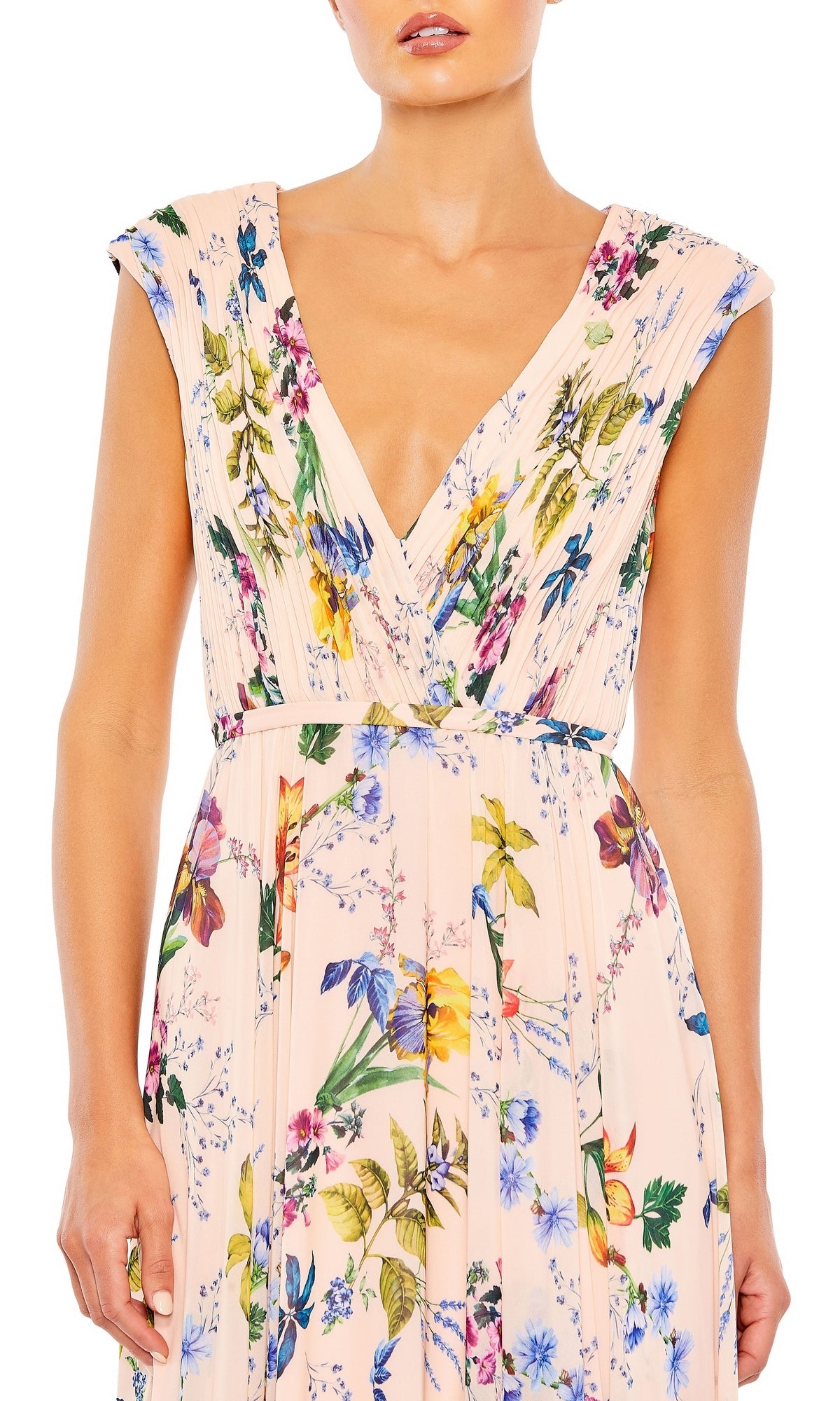 A woman wears the Mac Duggal 55829 Long Floral-Print Formal Dress, featuring a sleeveless V-neck, pleated bodice, and pastel floral print for an elegant evening look.